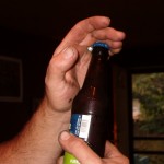 Hook ring under bottle cap and close fingers over the top