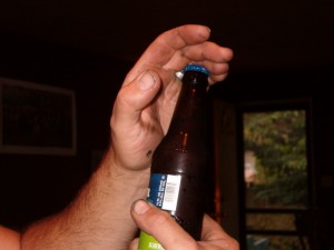 Hook ring under bottle cap and close fingers over the top